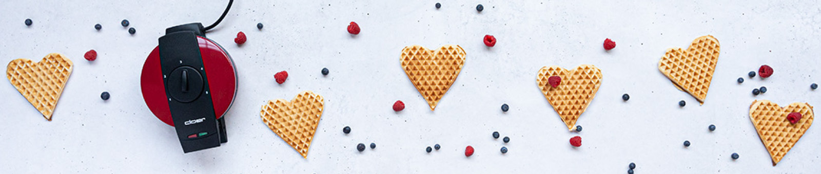 Das Bild zeigt das rote Cloer Valentinseisen 1633V und sechs große Waffelherzen.
