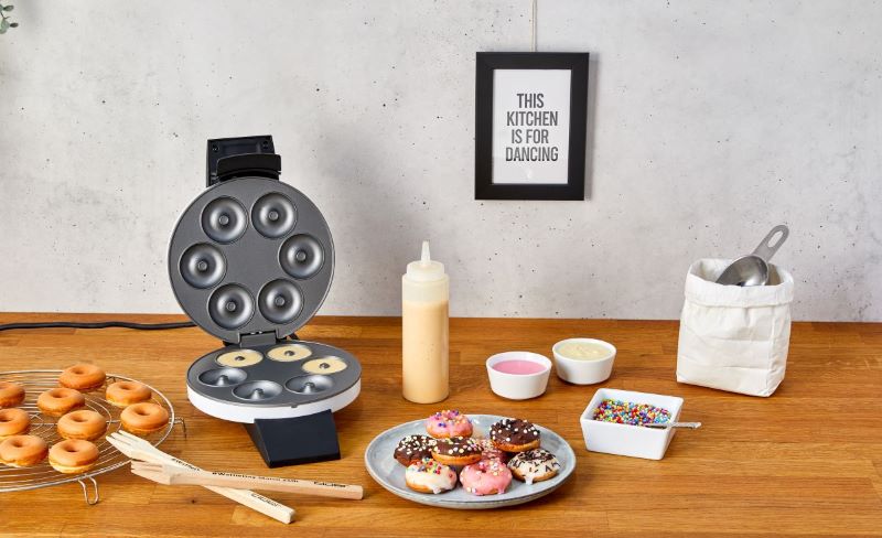Das Bild zeigt den Donut Maker Cloer 6121 und fertige Donuts. 