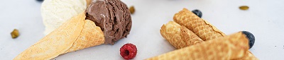 Das Bild zeigt Waffelhörnchen mit Schokoladen- und Vanilleeis und Beeren. 