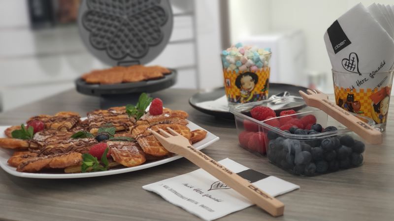 Das Bild zeigt Waffelherzen mit Schokosauce und Beeren.