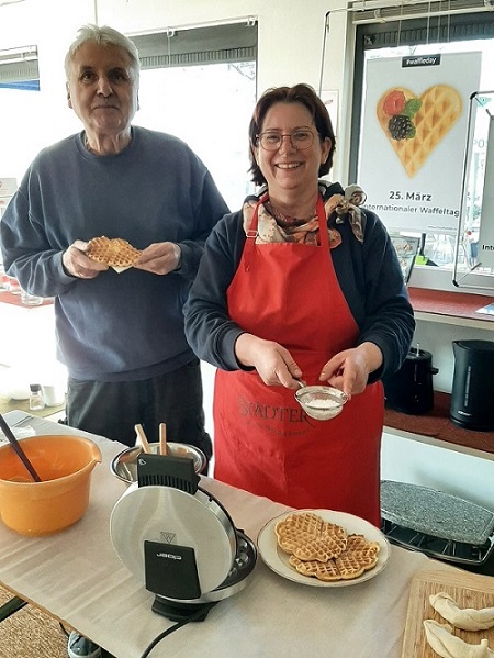 Ein Mann und eine Frau hinter einem Waffelstand