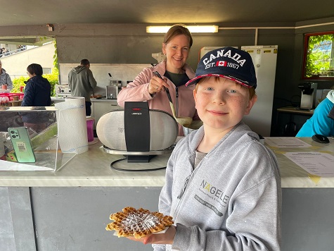 Das Bild zeigt einen Jungen mit einer Herzwaffel in der Hand.