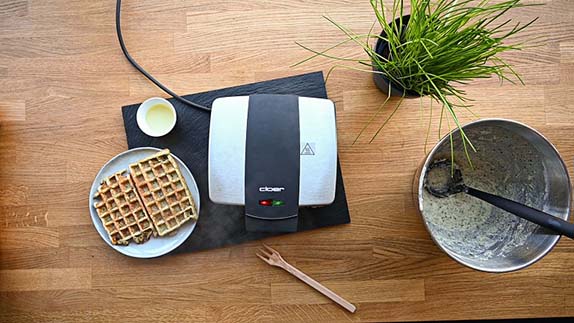 Das Bild zeigt Kartoffelwaffeln und daneben das Waffeleisen Cloer-1445.