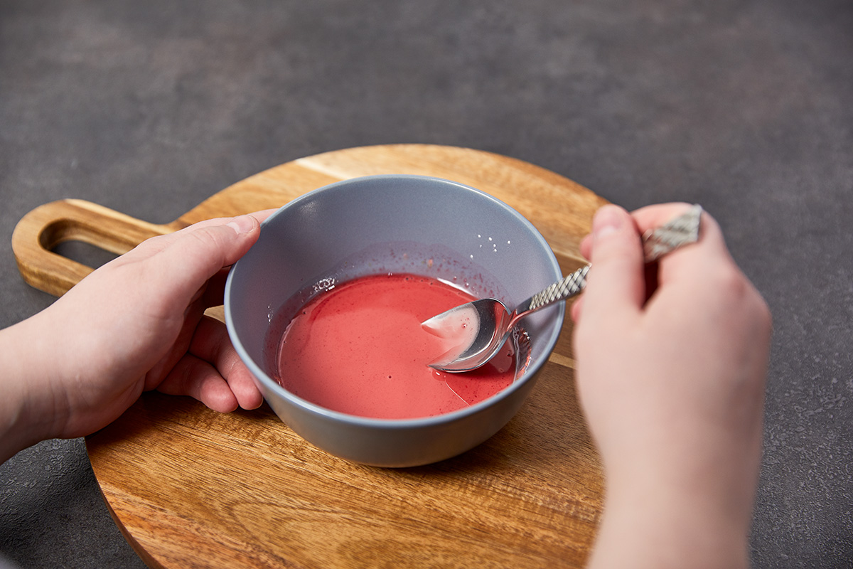 Das Bild zeigt wie das Vanillepuddingpulver mit dem Kirschsaft verrührt wird.