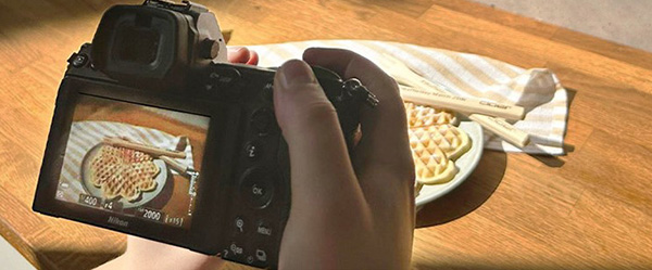 Das Bild zeigt wie eine Herzwaffel mit einer Kamera fotografiert wird.