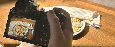 Das Bild zeigt wie eine Herzwaffel mit einer Kamera fotografiert wird.